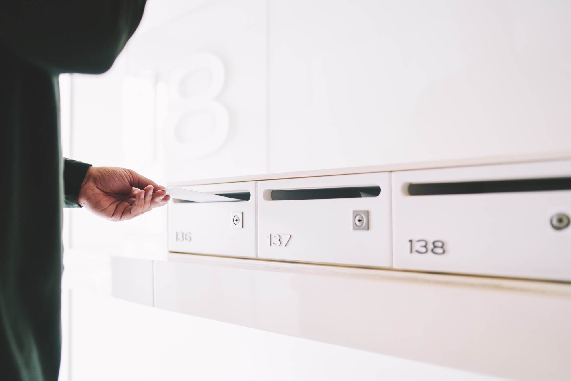 Courier inserting letter into postal box